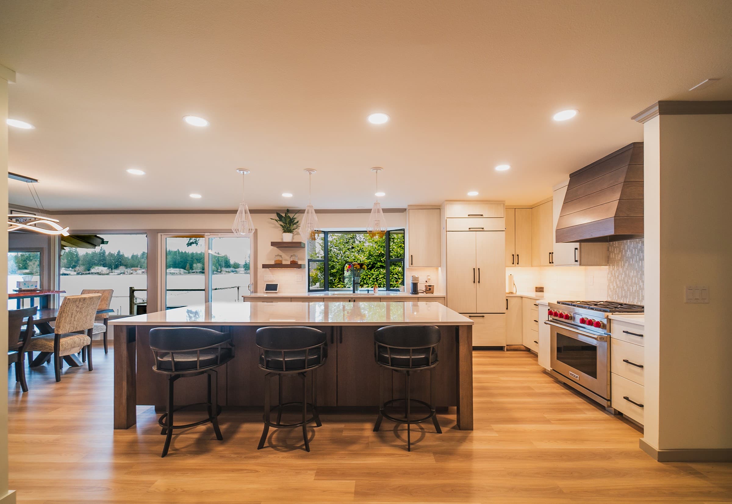 Lake Sawyer kitchen with a wood island, white cabinetry, wood range hood, and lake views